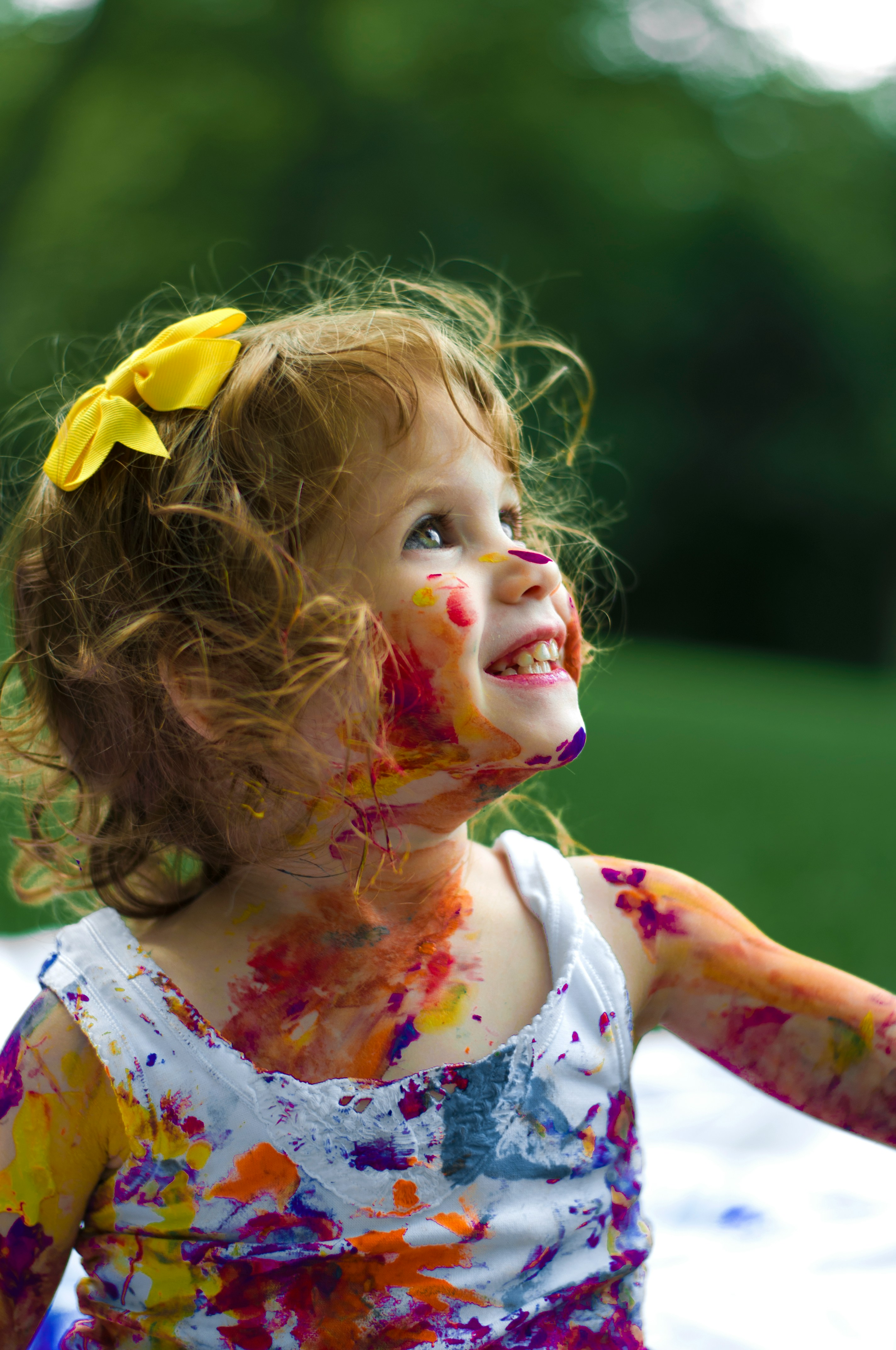 Happy girl with colorful face paint, showcasing creative expression and joyful engagement in therapy activities